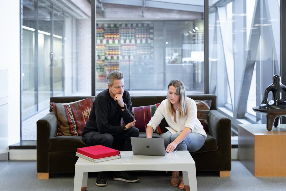 Two people working through a plan together on a laptop