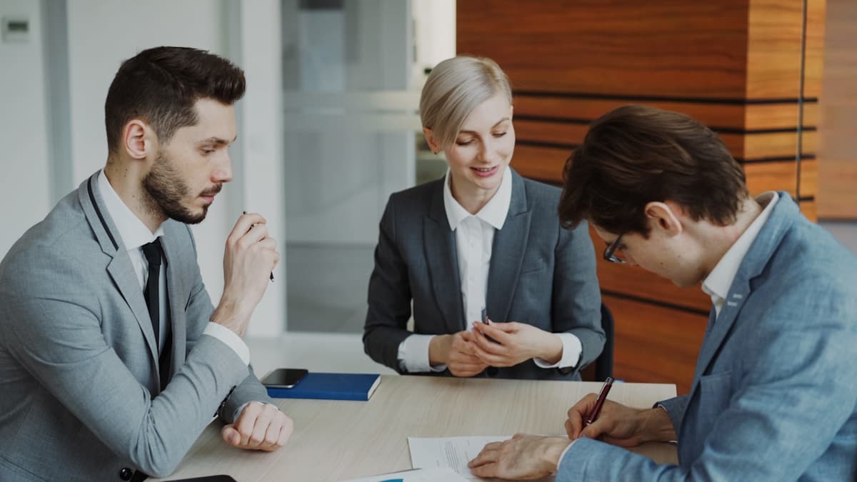 Professionals reviewing and signing a contract at a table