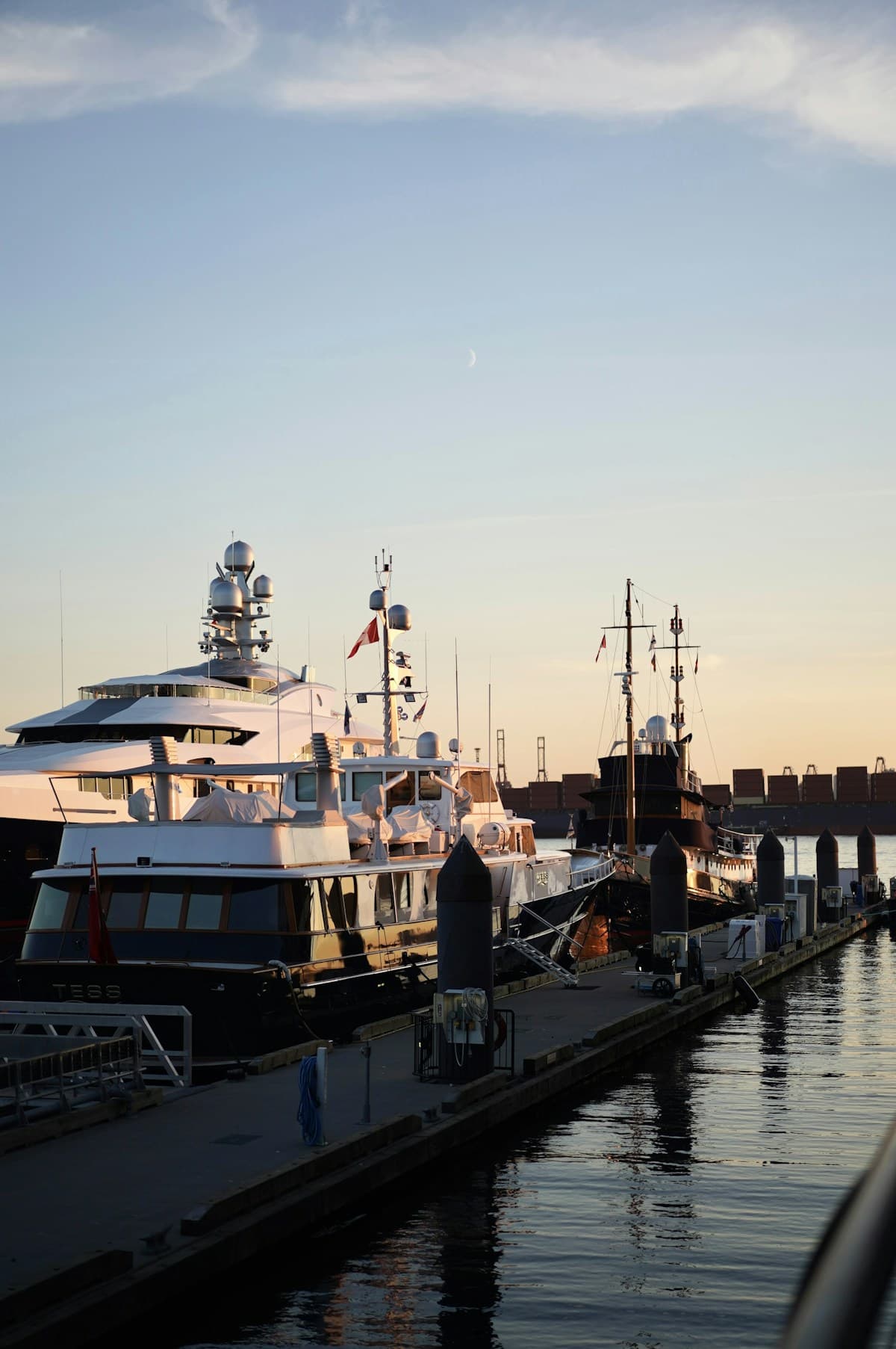 Yachts moored at a marina at golden hour