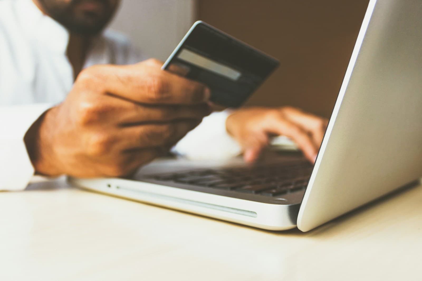 A person paying by card while shopping online on a laptop